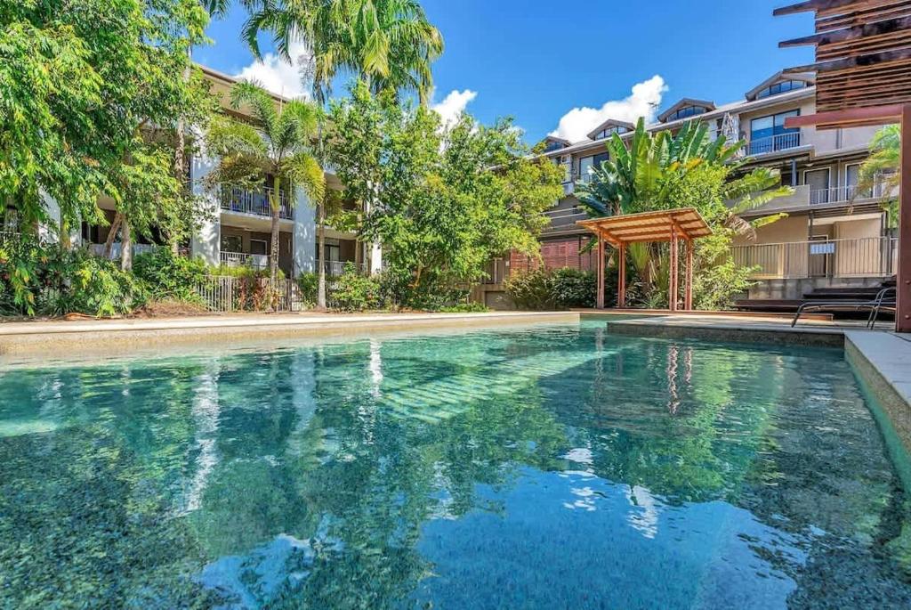 a swimming pool in front of a building at The Loft - Trendy Coastal Charm with Pool in Cairns