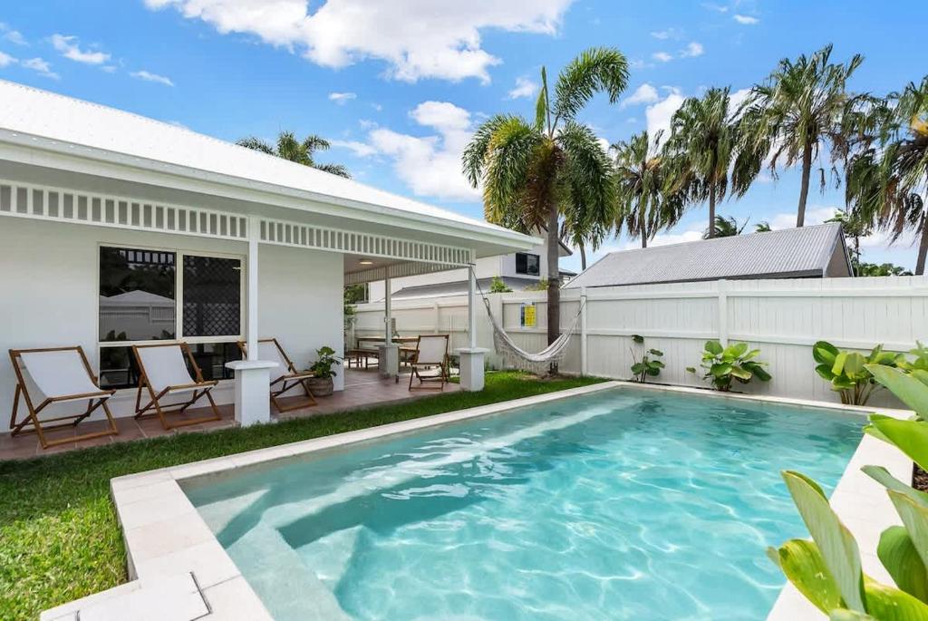 a swimming pool in the backyard of a house at The Bird House - Poolside Haven a Stroll from Beach in Palm Cove