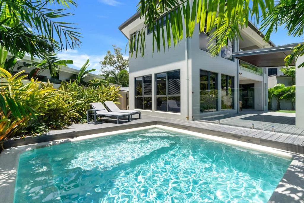 a swimming pool in front of a house at The Elysian at Argentea - Beachside Stay with Pool in Palm Cove