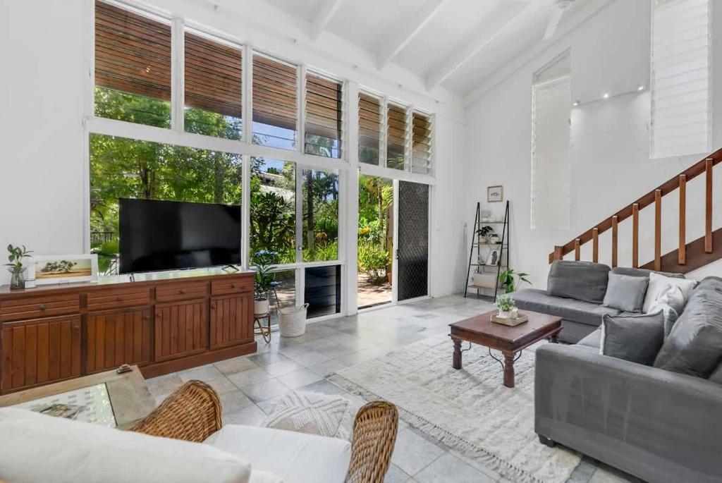 a living room with a couch and a tv at Nirvana - Steps to Four Mile Beach with Shared Pool in Port Douglas