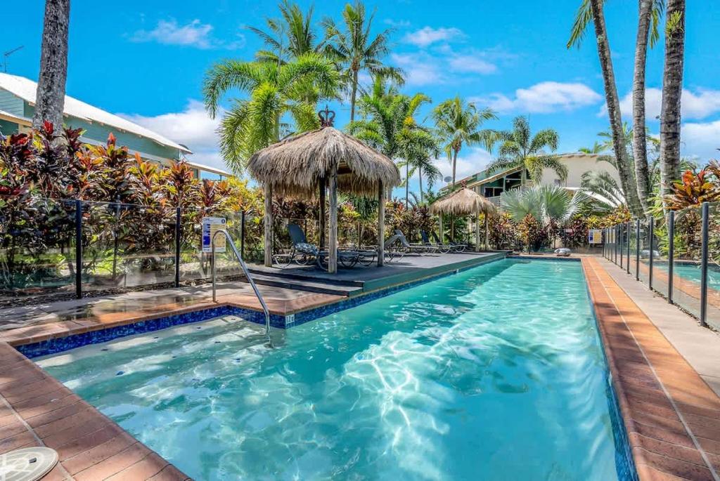 a pool at a resort with palm trees at Wallaby Beach House - Resort-style Comforts in Trinity Beach