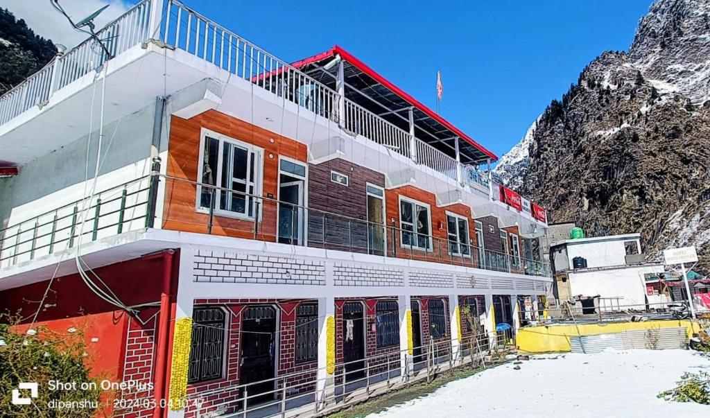 a building with a mountain in the background at Hotel Mansarovar in Pāndukeshwar