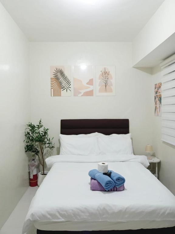 a bedroom with a white bed with towels on it at Unit 208 Venus Transients-Brenthill in Baguio