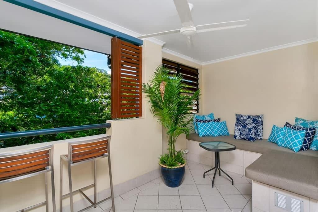 a balcony with a table and chairs and a plant at Escape for Two - A Boutique Tropical Treasure in Port Douglas