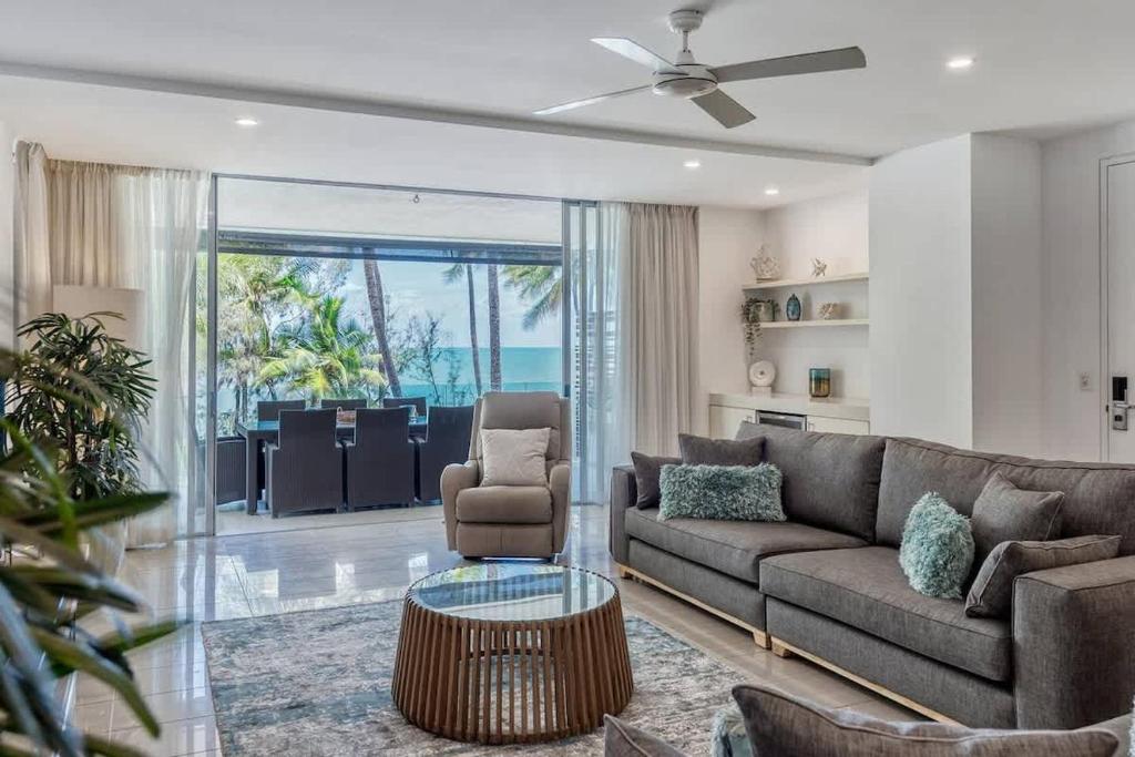 a living room with a couch and a table at Bougainvillea - Beachside Luxury at The Drift in Palm Cove