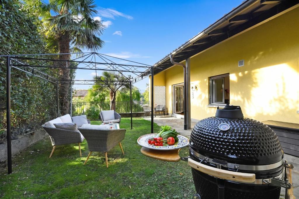 a grill in a yard with a table and chairs at Ca' Lidia - Lugano Villa with Garden and Parking - Happy Rentals in Pregassona