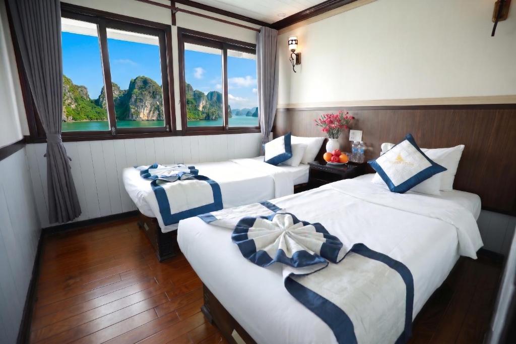 two beds in a room with two windows at Sunlight Legend Cruise in Ha Long