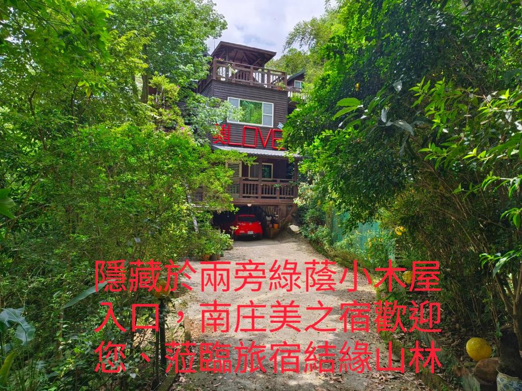 a house with a sign in the middle of trees at Beauty House in Nanzhuang