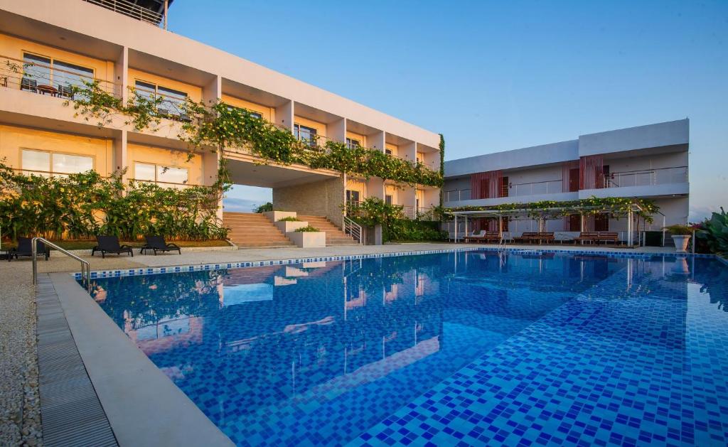a large swimming pool in front of a building at Panja Resort Palawan in Puerto Princesa City