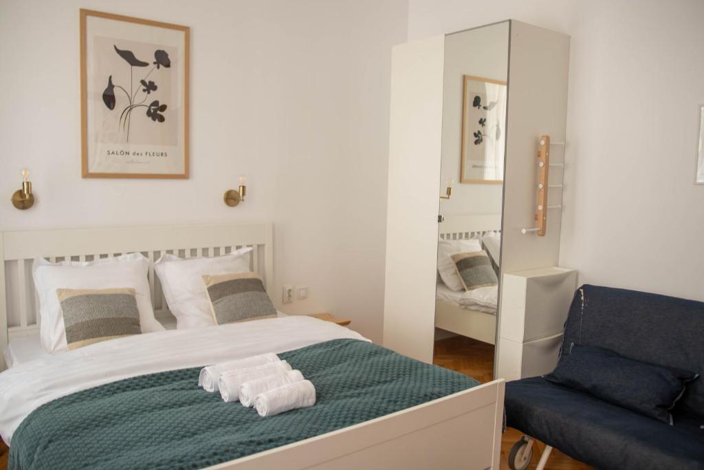 a bedroom with a bed and a blue chair at Studio Old Town with Jacuzzi and View in Bucharest