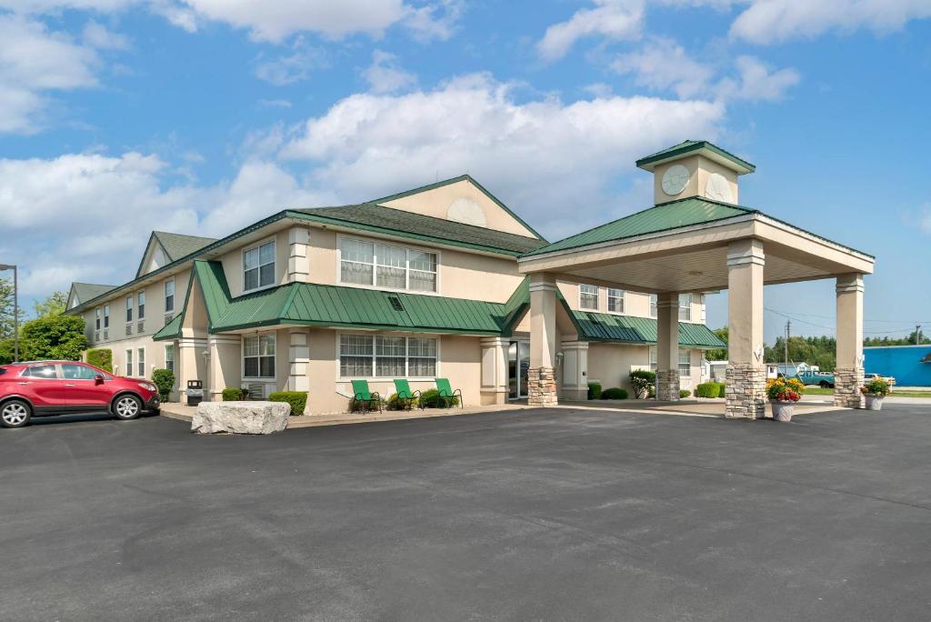 a large building with a car parked in a parking lot at Quality Inn & Suites Manistique in Manistique