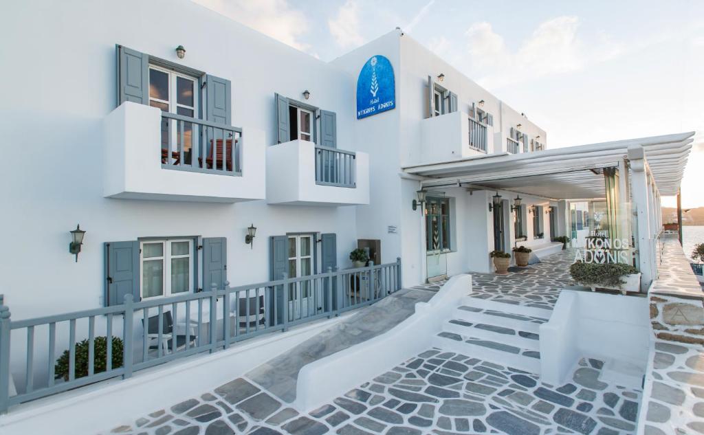 un edificio blanco con ventanas azules y una escalera en Hotel Adonis en Mykonos