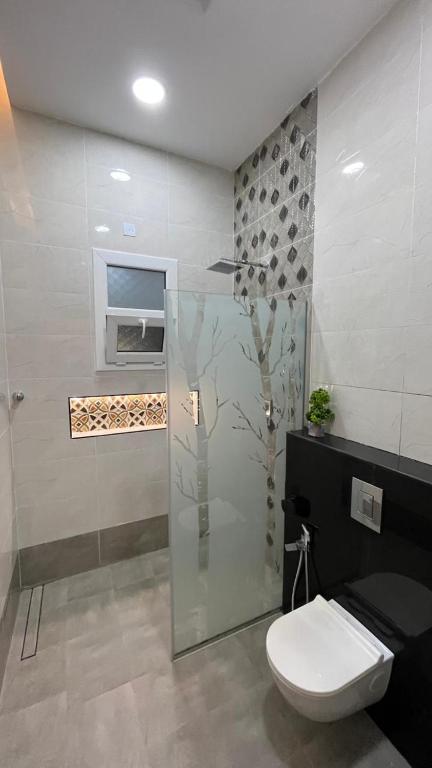 a bathroom with a toilet and a glass shower at استراحه بيت الزلفى in Fulūj Sayghah