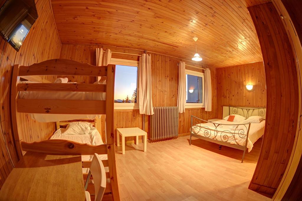 Un pat sau paturi într-o cameră la Auberge du Virage