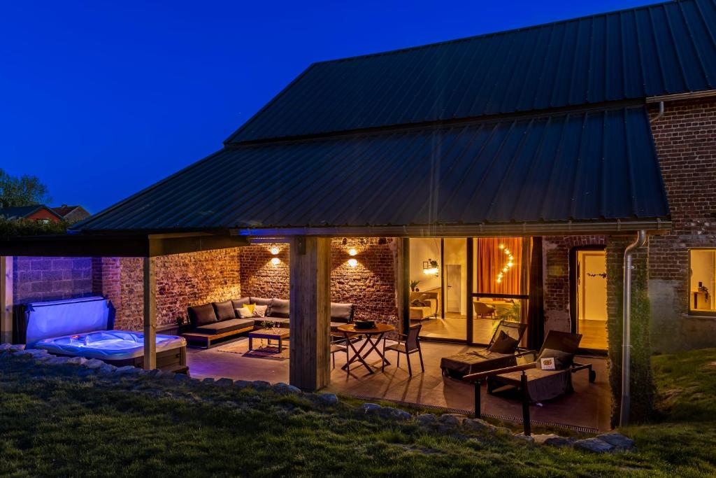 a patio with a brick building with a black roof at Wellnesshoeve in Boutersem