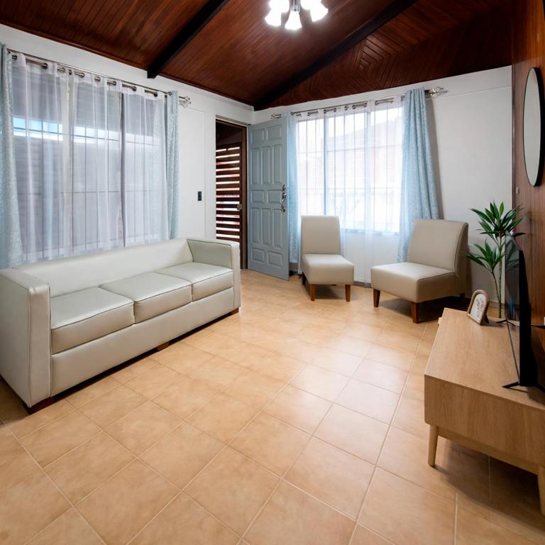 a living room with a white couch and two chairs at La Casa del Centro in Quesada