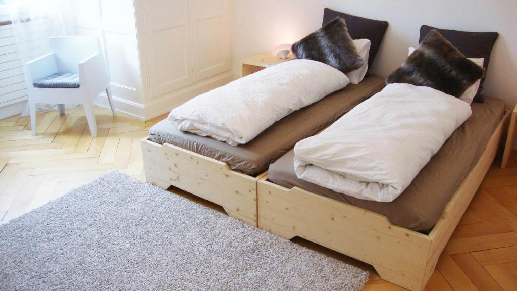 a wooden bed with two pillows on it in a room at B&B Laupenring, Basel in Basel