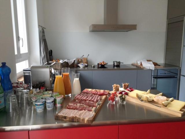 a kitchen with meat and cheese on a counter at B&B Laupenring, Basel in Basel