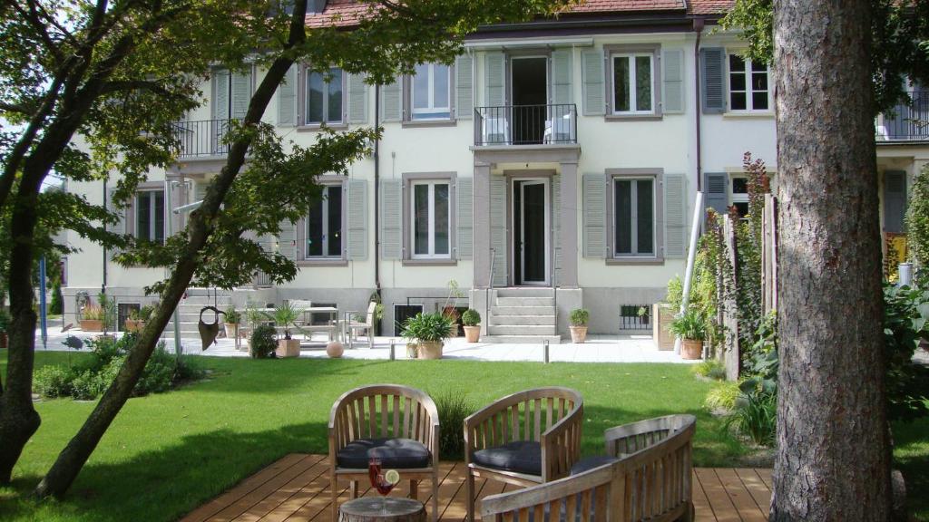 a patio with two chairs and a table in front of a building at B&B Laupenring, Basel in Basel