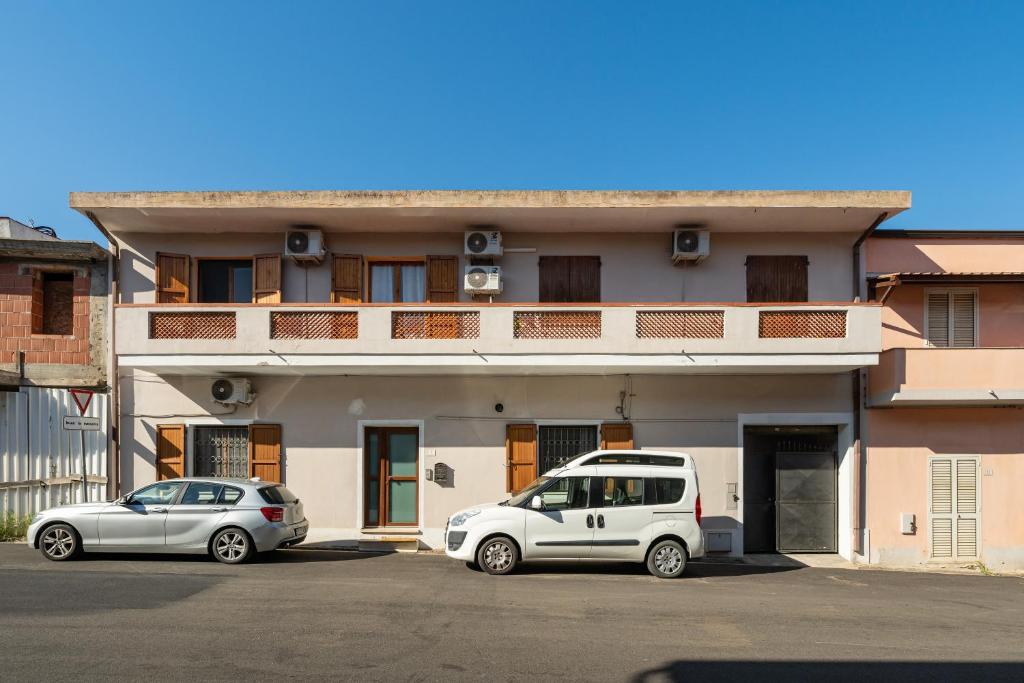 two cars parked in a parking lot in front of a building at Piccola Casa Melis in Capoterra