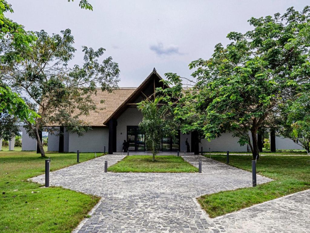 a building with trees in front of it at Bon Hotel Crown Forest in Nsuaem