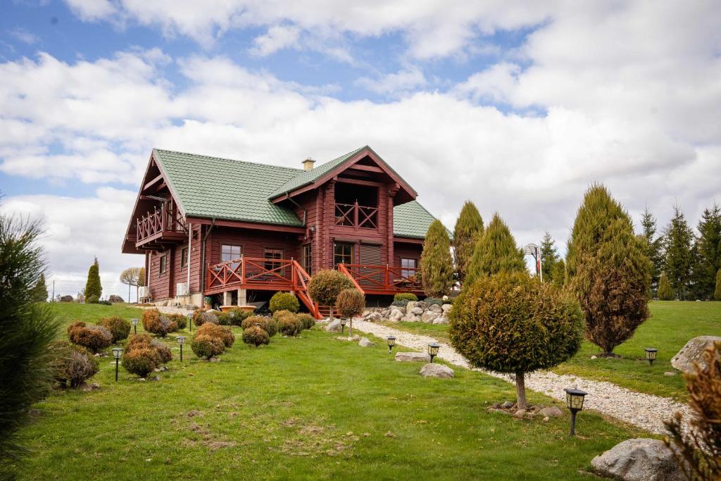 a log cabin with a garden in front of it at Lake House Villa pas Eugenija in Migiškiai