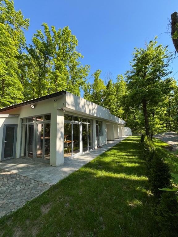 a building with a green lawn in front of it at Woodland Retreat in Ampoiţa