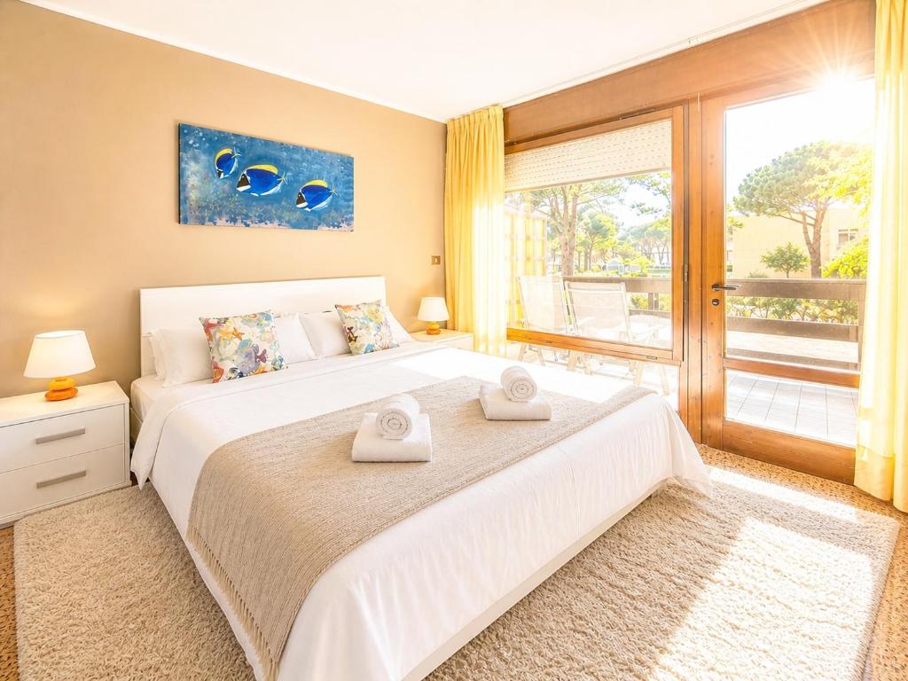 a bedroom with a large bed with two towels on it at Beach House Riviera in Lignano Sabbiadoro