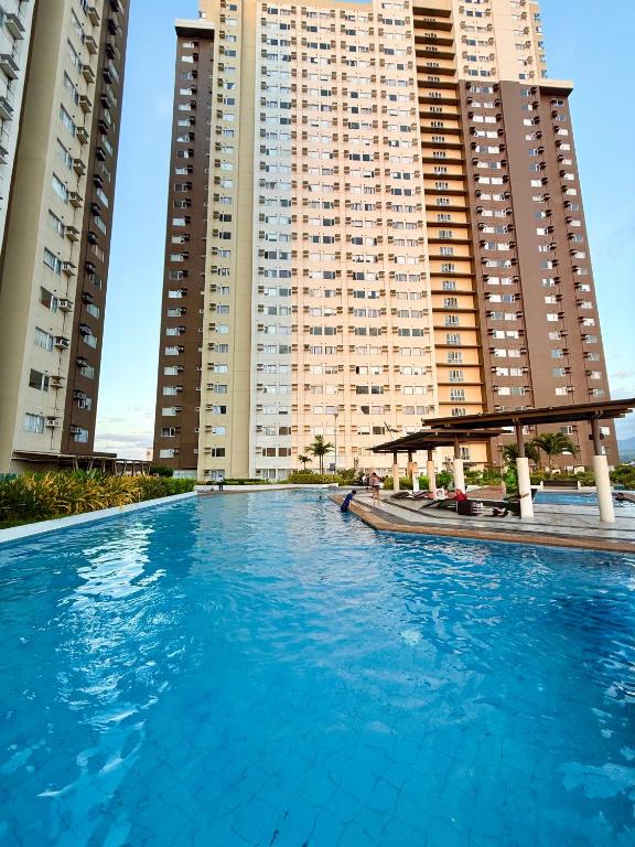 a large swimming pool in front of tall buildings at Avida Aspira Studio, 27th Floor, Pool & Gym in Cagayan de Oro