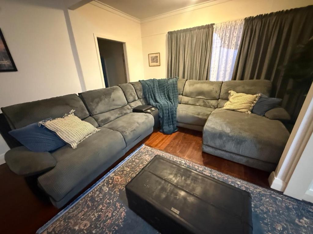 a living room with a couch and a table at Huge comfy 4br home near CBD in Geraldton