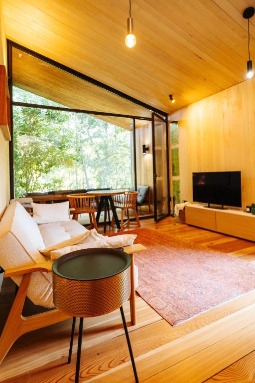 a living room with a couch and a table at The Grit - Adults-Only Modern Design House near Brașov in Vama Buzăului