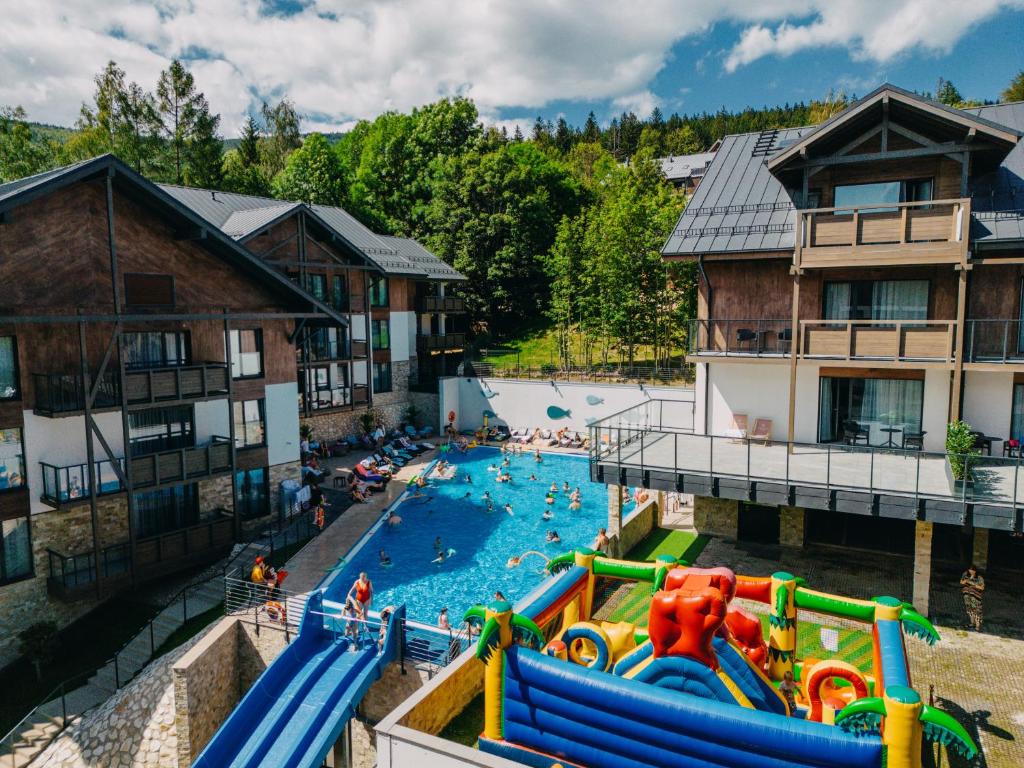 an outdoor swimming pool with people in the water at Elements Apartments in Świeradów-Zdrój