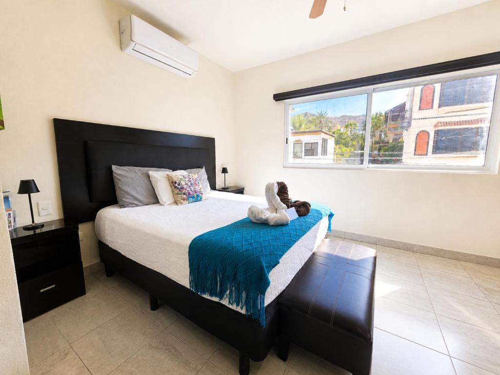 a bedroom with a bed with a teddy bear on it at Cabo Downtown Studios in Cabo San Lucas