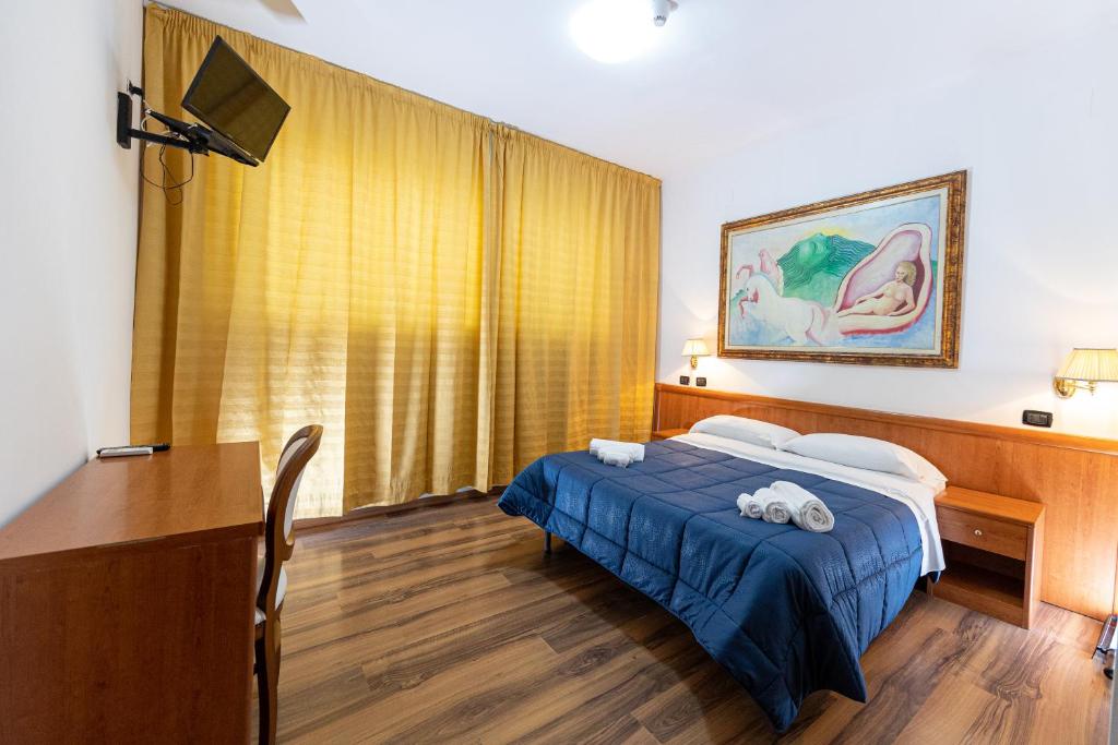 a bedroom with a bed and a desk and a table at B&B H Pompeii Ruins in Pompei
