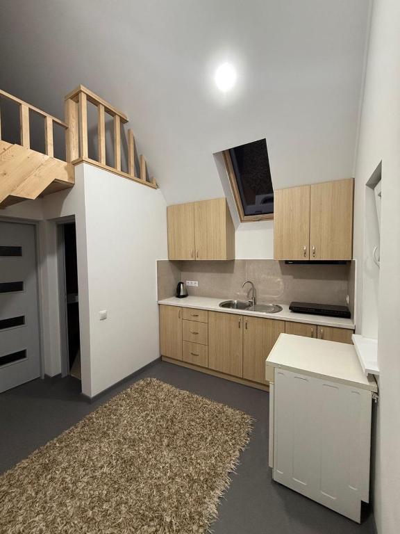 a kitchen with wooden cabinets and a sink and a rug at Apartament in Chişinău