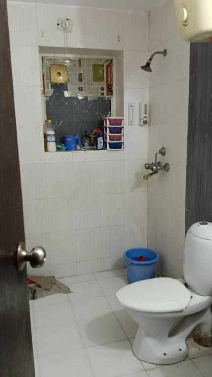a bathroom with a white toilet and a shower at Shubharohi stay in Chhatikara