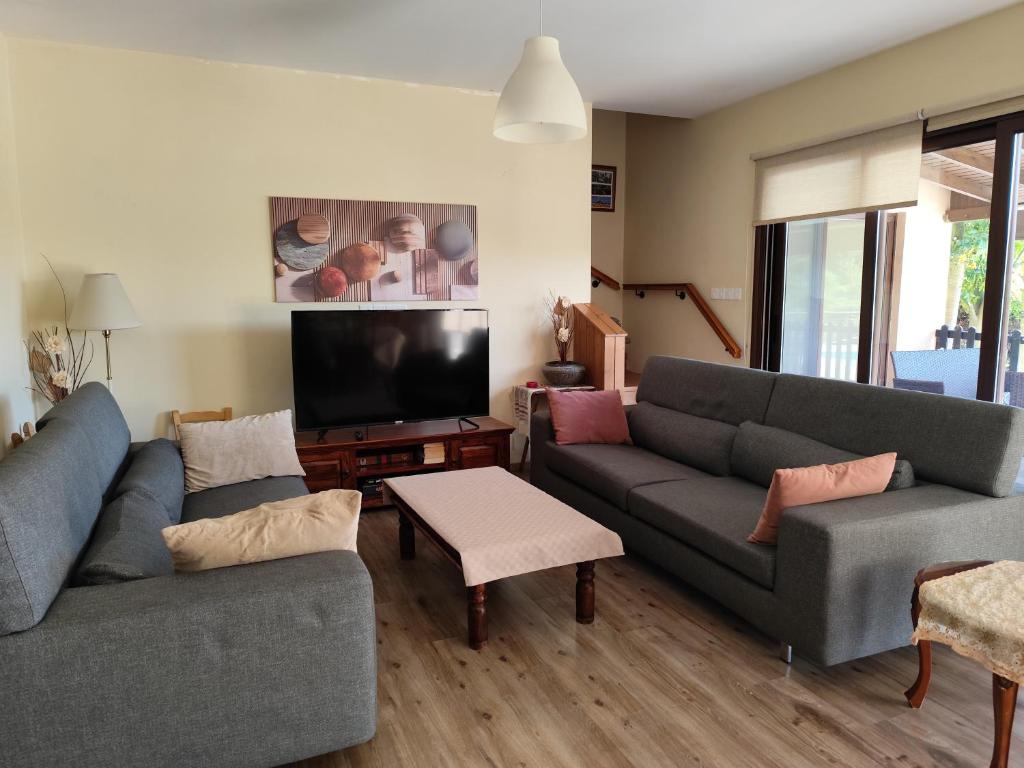 a living room with two couches and a flat screen tv at Roses Villa in Trimiklini