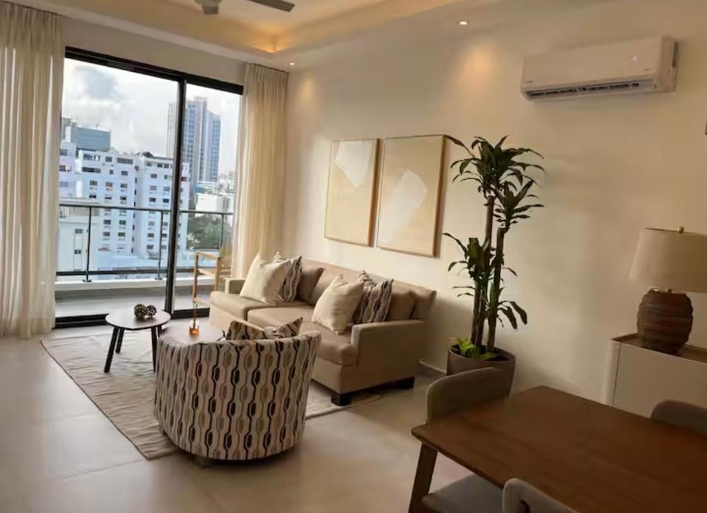 a living room with a couch and a large window at Torre meridt in Santo Domingo