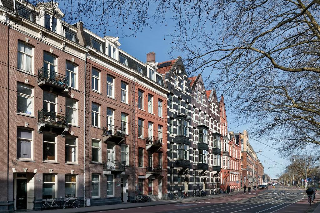a row of brick buildings on a city street at Marnix360apartments-Suites Jordaan in Amsterdam