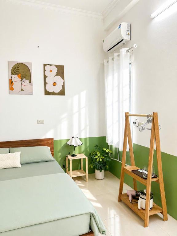 a bedroom with a bed and a green and white wall at La Pausa Homestay in Kỳ Vĩ