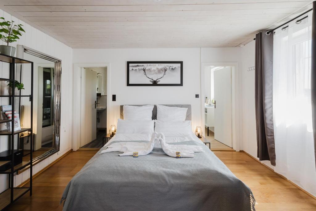 a bedroom with a large bed with white sheets and pillows at Danube Rooms Abteistrasse - Self Checkin - kostenlos Parken direkt an der Unterkunft - Ideal für Geschäftsreisende und Städtetrips in Passau