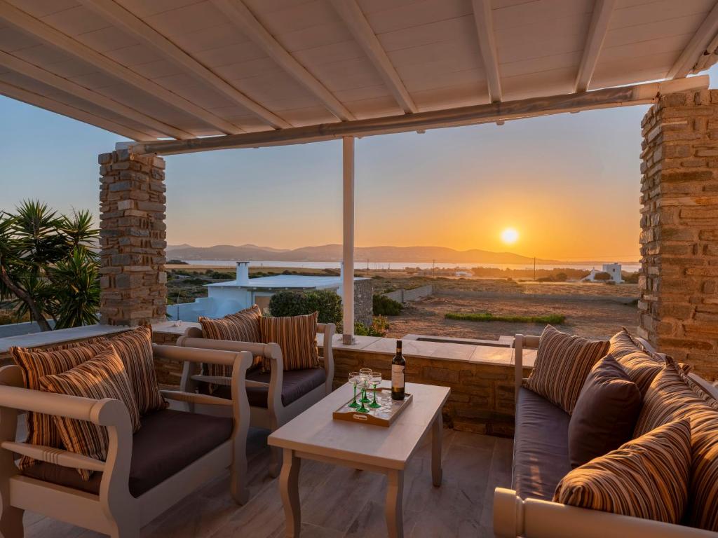 a patio with couches and a table with a sunset at Angel Serenity Villa in Kampos Paros
