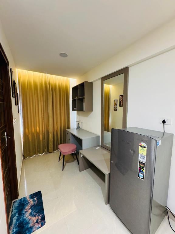 a small room with a desk and a refrigerator at Candlewick Homestays in Jaipur