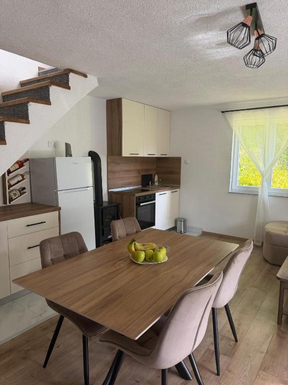 a kitchen with a wooden table with a bowl of fruit on it at Vikendica Markić in Šipovo
