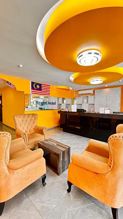 a lobby with chairs and a desk and a clock at Bright Hotel in Petaling Jaya