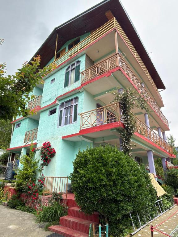 a blue building with red stairs in front of it at Nirvana Stays and Cafe in Manāli