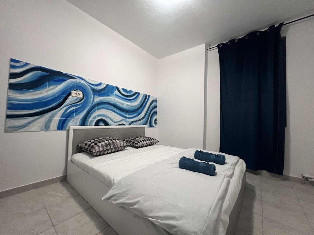a bedroom with a bed with a painting on the wall at LaScena in Techirghiol