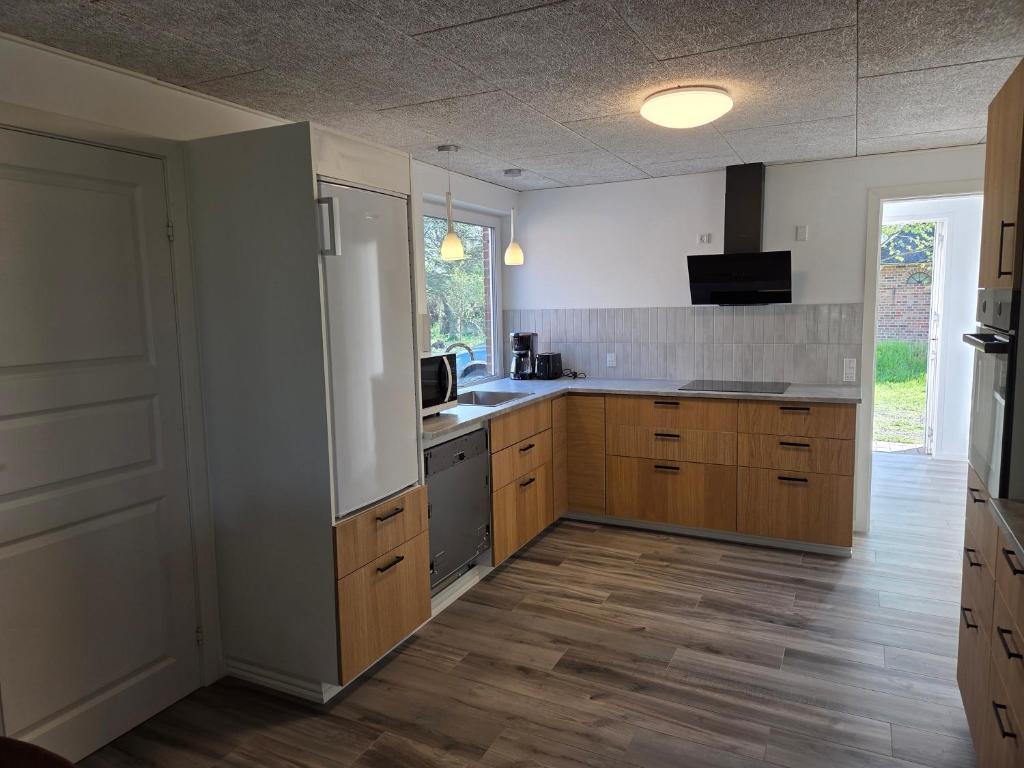 a kitchen with wooden cabinets and a refrigerator at Harknakvej 19BB in Bredebro