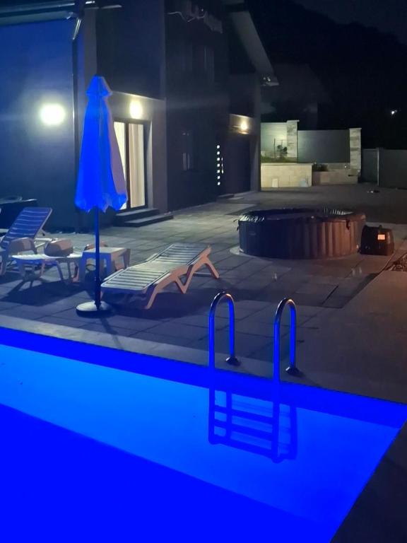 a swimming pool with a blue light in a room at Villa Aqua Tuzla in Drenovik