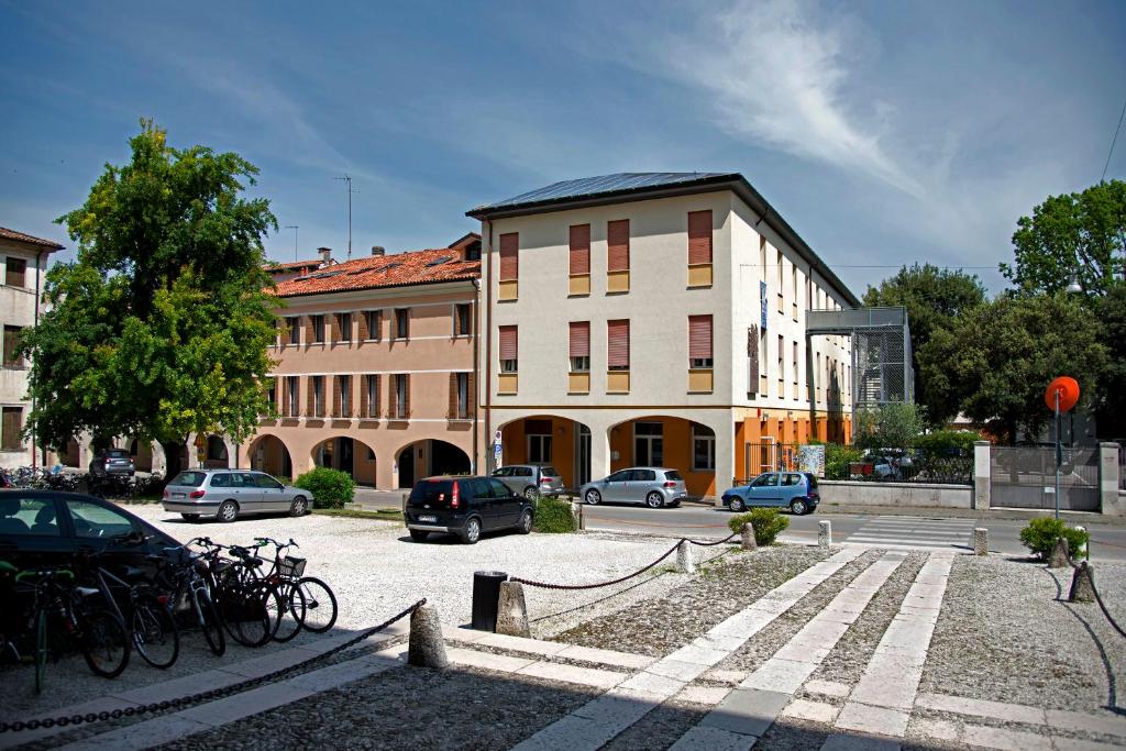 a building with cars parked in a parking lot at Centro della Famiglia in Treviso
